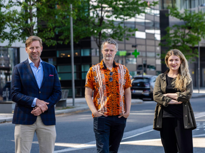 Mathis Grimstad, Erling Fossen og Silje Kristiansen står i et urbant miljø og ser rett mot kamera
